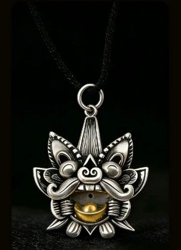 Shouxin pendant on a black chain against a black background, citrine glowing
